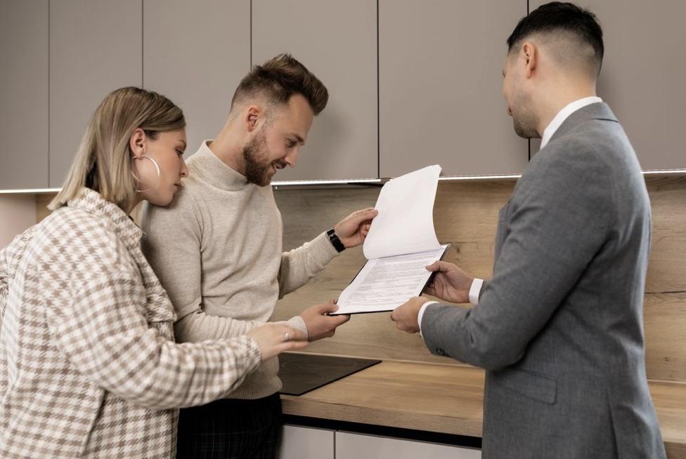 A couple reviewing paperwork with their agent