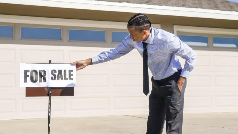 A for-sale sign in front of a listed home